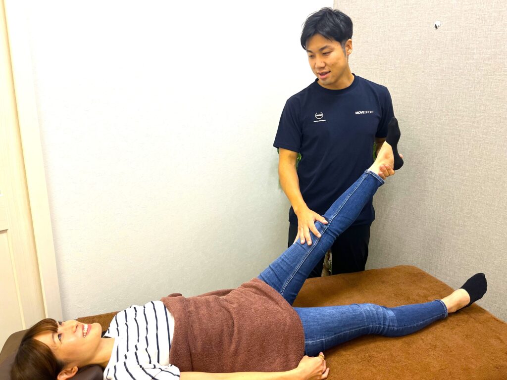 仰向けの状態で脚の動きと可動域を評価している様子