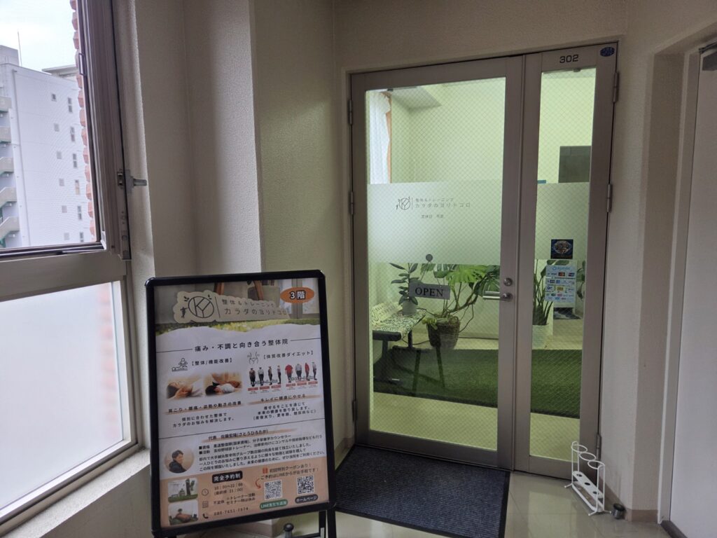 カラダのヨリドコロの入口ドア302号室と案内看板